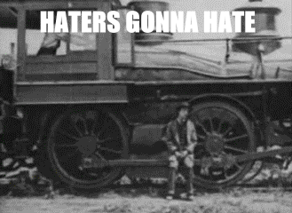 Haters Gonna Hate. .. He's a hipster. Apparently riding inside the train is too mainstream.